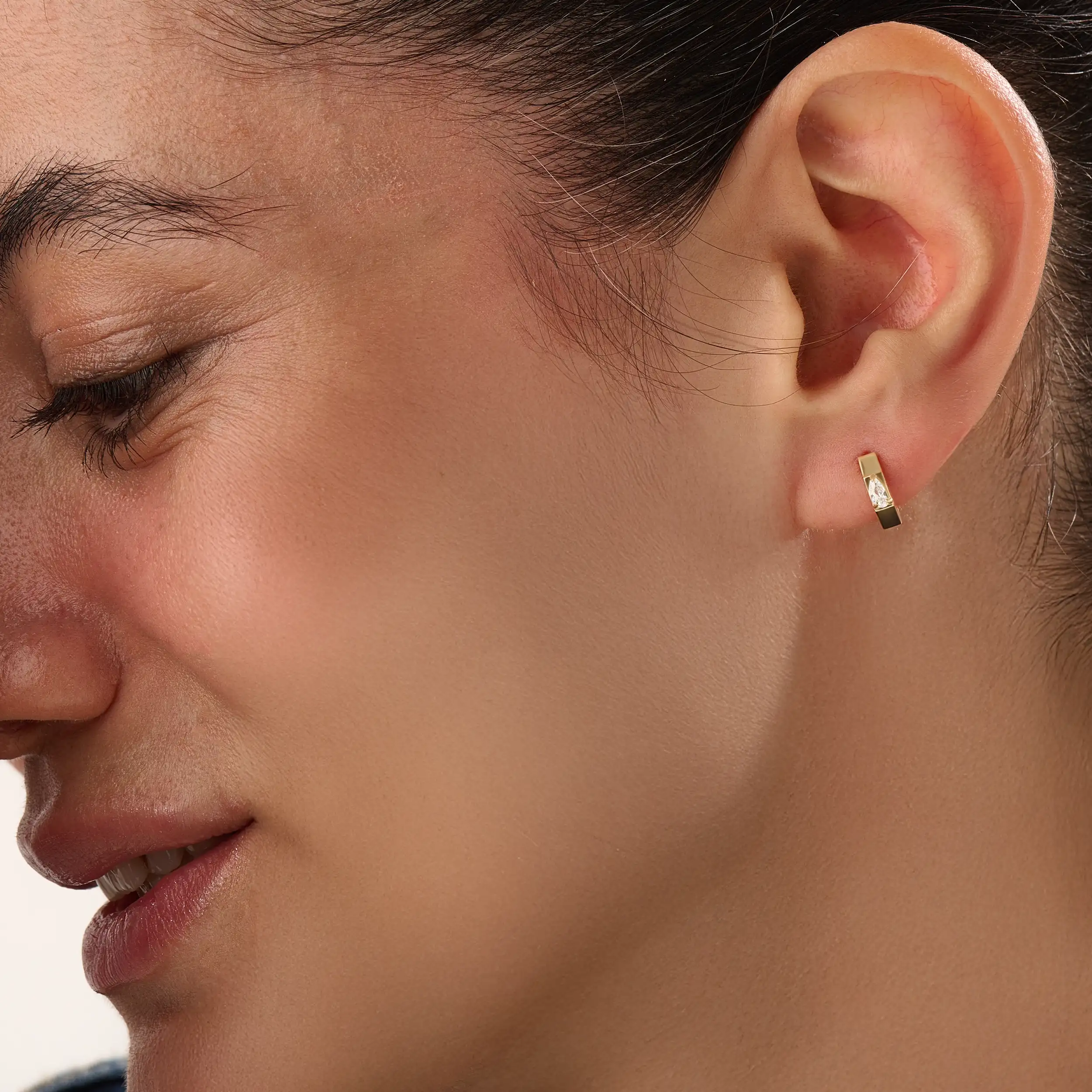 Model wearing 14k gold vermeil solo pear hoop earrings displaying the striking pear-cut gem and sculpted gold finish — perfect for elegant minimalism.
