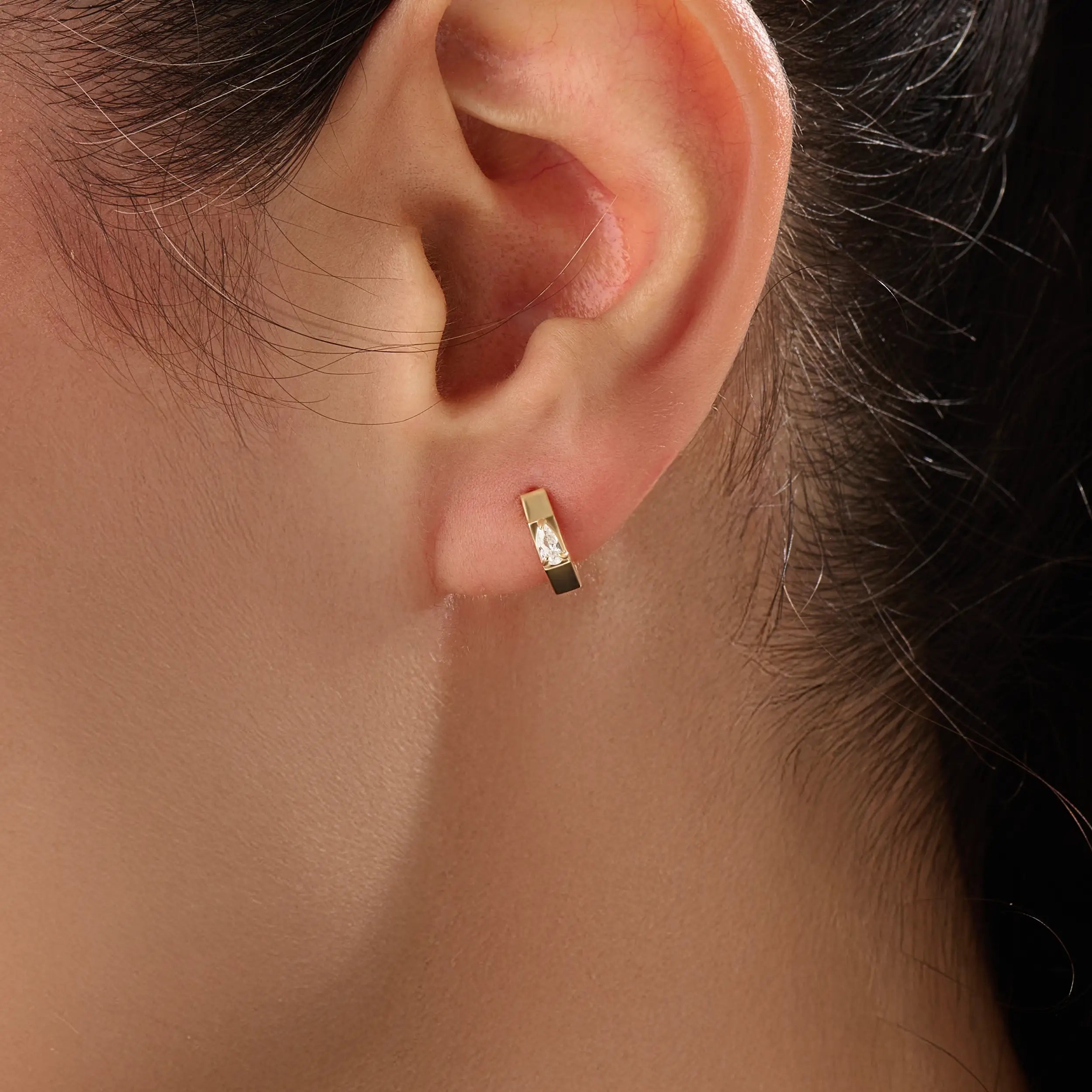 Model wearing 14k gold vermeil solo pear hoop earrings displaying the striking pear-cut gem and sculpted gold finish — perfect for elegant minimalism.
