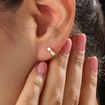 Model wearing 14k gold vermeil solo pear hoop earrings displaying the striking pear-cut gem and sculpted gold finish — perfect for elegant minimalism.
