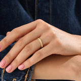 Model wearing a 14k gold vermeil square band ring featuring a faceted pyramid design that catches light beautifully for a sleek, contemporary statement.
