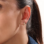 Model wearing 14k gold vermeil star hoop earrings showcasing a luminous gold finish and twinkling stone details, perfect for adding celestial elegance to any outfit.
