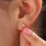 Model wearing 14k gold vermeil star stud earrings with a radiant starburst silhouette that brings subtle shine and celestial beauty to everyday style.
