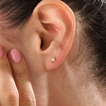 Model wearing 14k gold vermeil star stud earrings with a radiant starburst silhouette that brings subtle shine and celestial beauty to everyday style.
