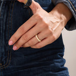 Model wearing a 14k gold vermeil striped ring with its reflective beaded pattern catching the light, adding a refined touch to any look.
