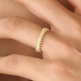Model wearing a 14k gold vermeil striped ring with its reflective beaded pattern catching the light, adding a refined touch to any look.
