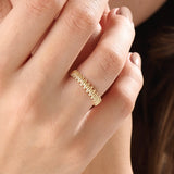 Model wearing a 14k gold vermeil striped ring with its reflective beaded pattern catching the light, adding a refined touch to any look.
