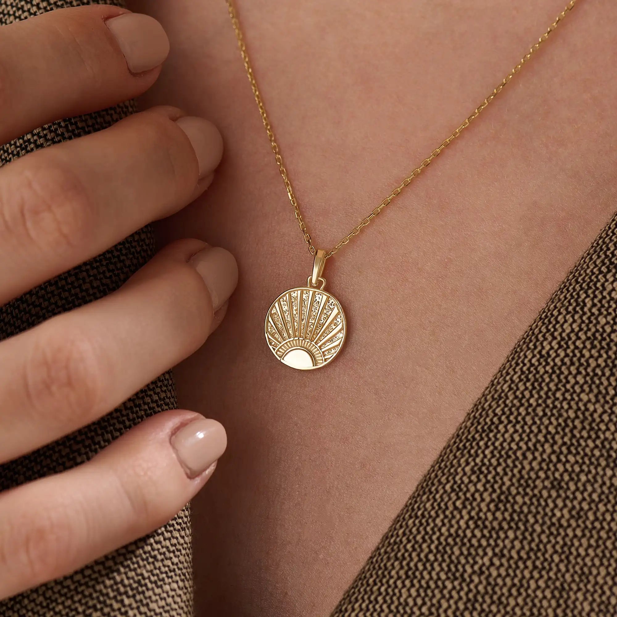 Model wearing a 14k gold vermeil sunrise coin necklace featuring a radiant engraved sun pendant that adds a golden touch of warmth and elegance to any outfit.
