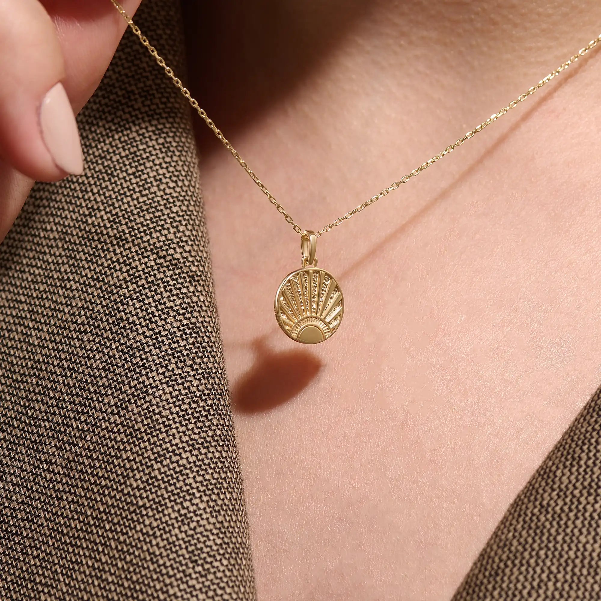 Model wearing a 14k gold vermeil sunrise coin necklace featuring a radiant engraved sun pendant that adds a golden touch of warmth and elegance to any outfit.
