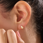 Model wearing 14k gold vermeil teardrop stud earrings that capture light with their glossy, rounded teardrop design for a sophisticated finish.
