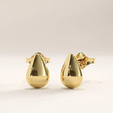 Side view of 14k gold vermeil teardrop stud earrings showing the curved contours and polished surface for a modern, understated style.
