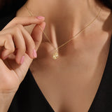 Model wearing a 14k gold vermeil textured coin necklace featuring a radiant beaded pendant with a central cubic zirconia, blending vintage charm with modern elegance.
