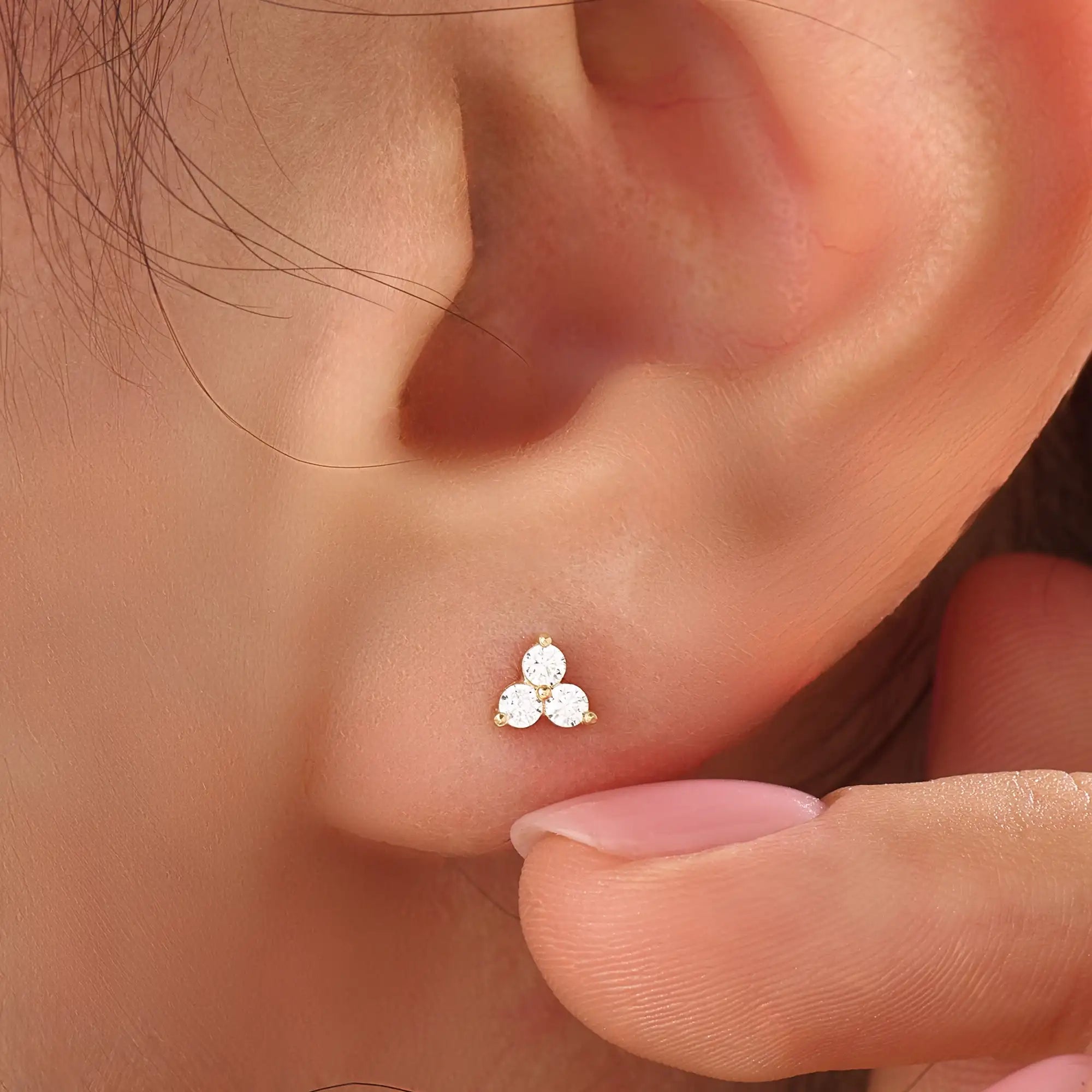 Model wearing 14k gold vermeil tiny trio earrings featuring a delicate cluster of three sparkling stones, perfect for layering or daily wear.
