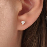 Model wearing 14k gold vermeil tiny trio earrings featuring a delicate cluster of three sparkling stones, perfect for layering or daily wear.
