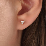 Model wearing 14k gold vermeil tiny trio earrings featuring a delicate cluster of three sparkling stones, perfect for layering or daily wear.
