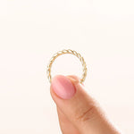 Model wearing a 14k gold vermeil twisted rope ring with a delicate braided design, adding subtle sophistication to any outfit.
