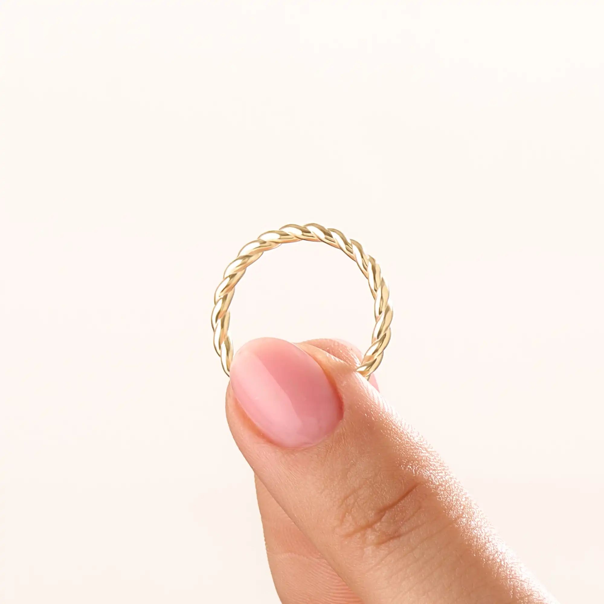 Model wearing a 14k gold vermeil twisted rope ring with a delicate braided design, adding subtle sophistication to any outfit.
