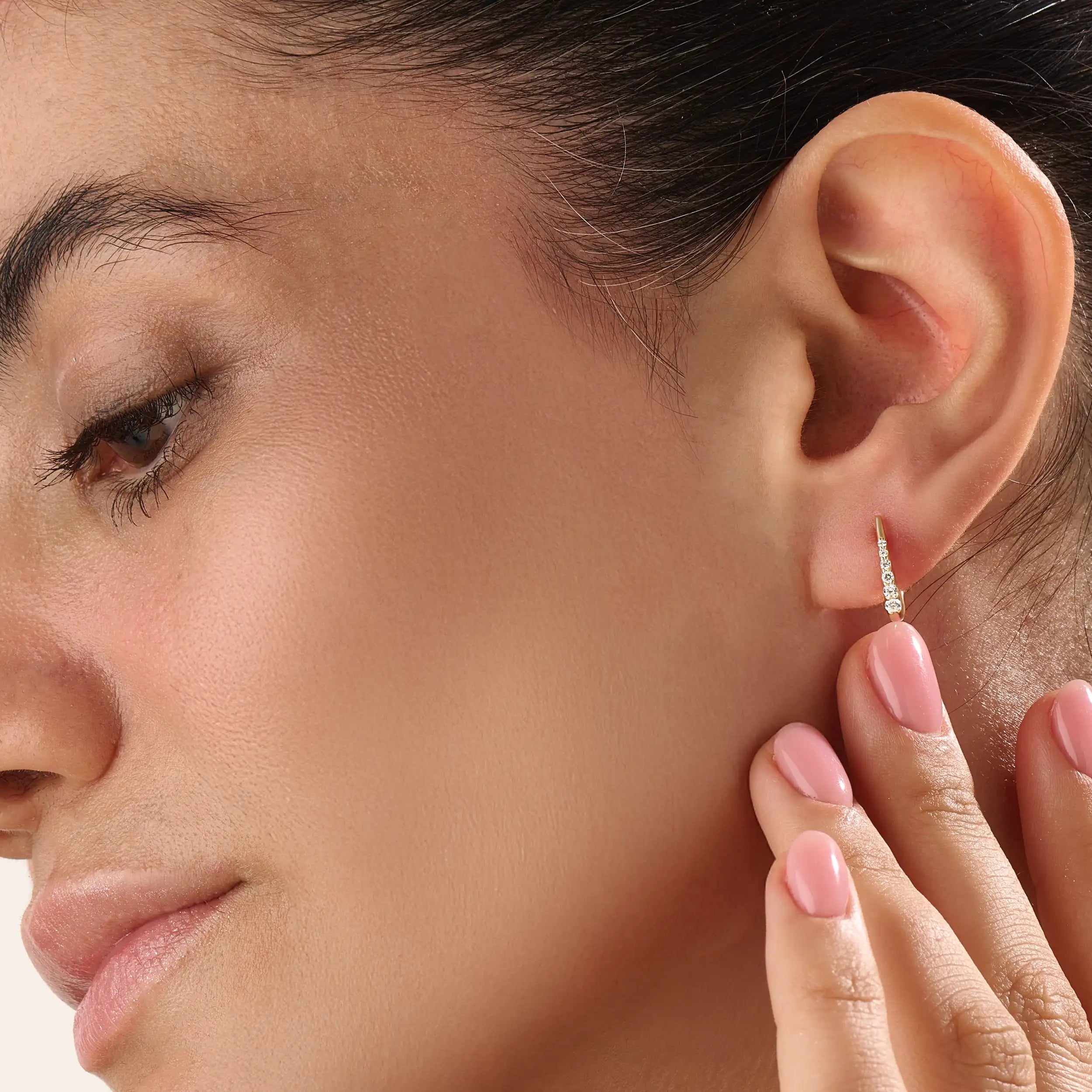 Model wearing 14k gold vermeil U shape hoop earrings that showcase their elegant curvature and radiant sparkle — perfect for both everyday wear and special occasions.
