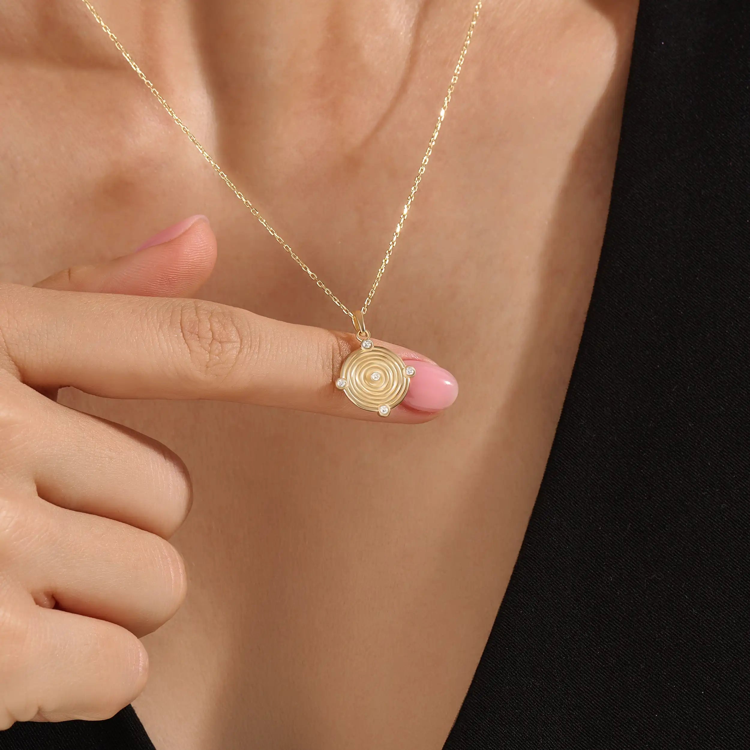 Model wearing a 14k gold vermeil unique round necklace featuring a dimensional circular pendant with radiant concentric rings and cubic zirconia accents for refined brilliance.
