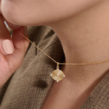 Model wearing a 14k gold vermeil unique round necklace featuring a dimensional circular pendant with radiant concentric rings and cubic zirconia accents for refined brilliance.
