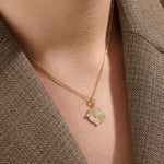 Model wearing a 14k gold vermeil unique round necklace featuring a dimensional circular pendant with radiant concentric rings and cubic zirconia accents for refined brilliance.
