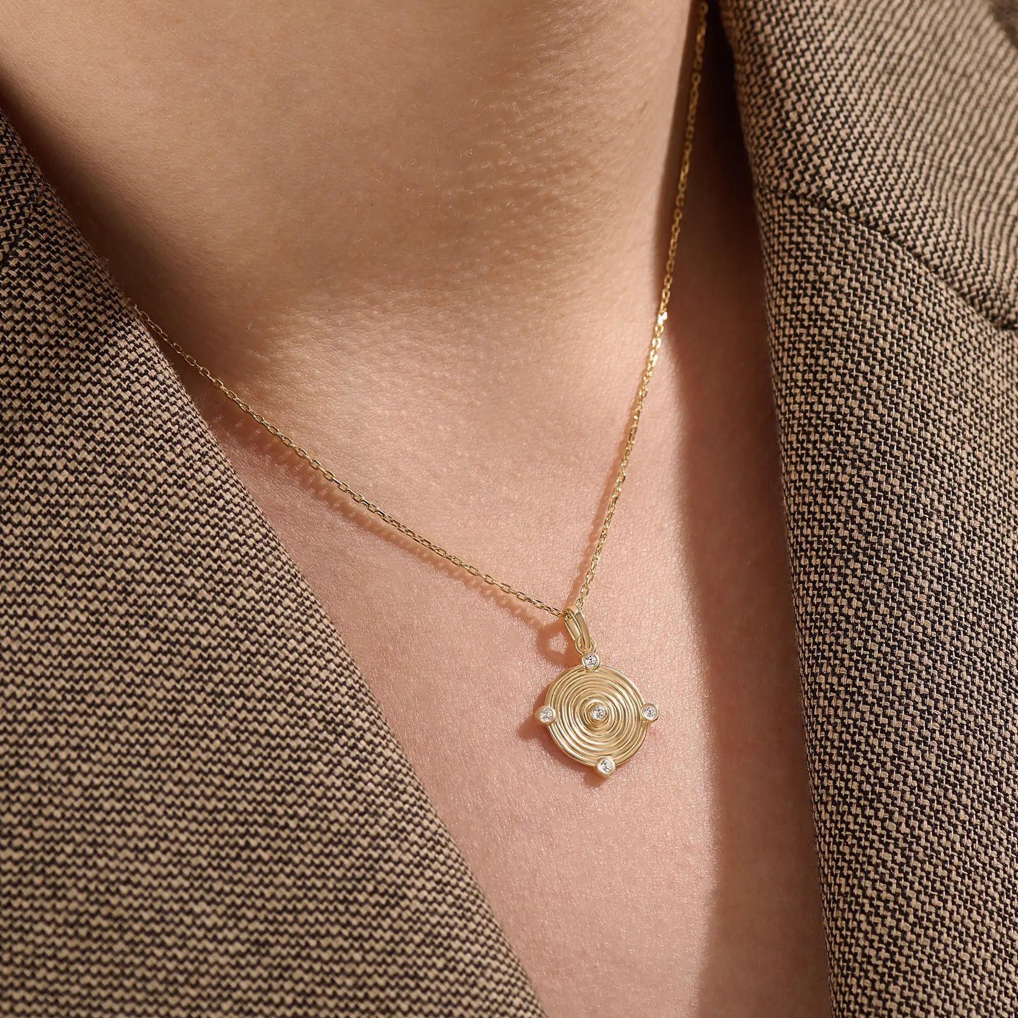 Model wearing a 14k gold vermeil unique round necklace featuring a dimensional circular pendant with radiant concentric rings and cubic zirconia accents for refined brilliance.
