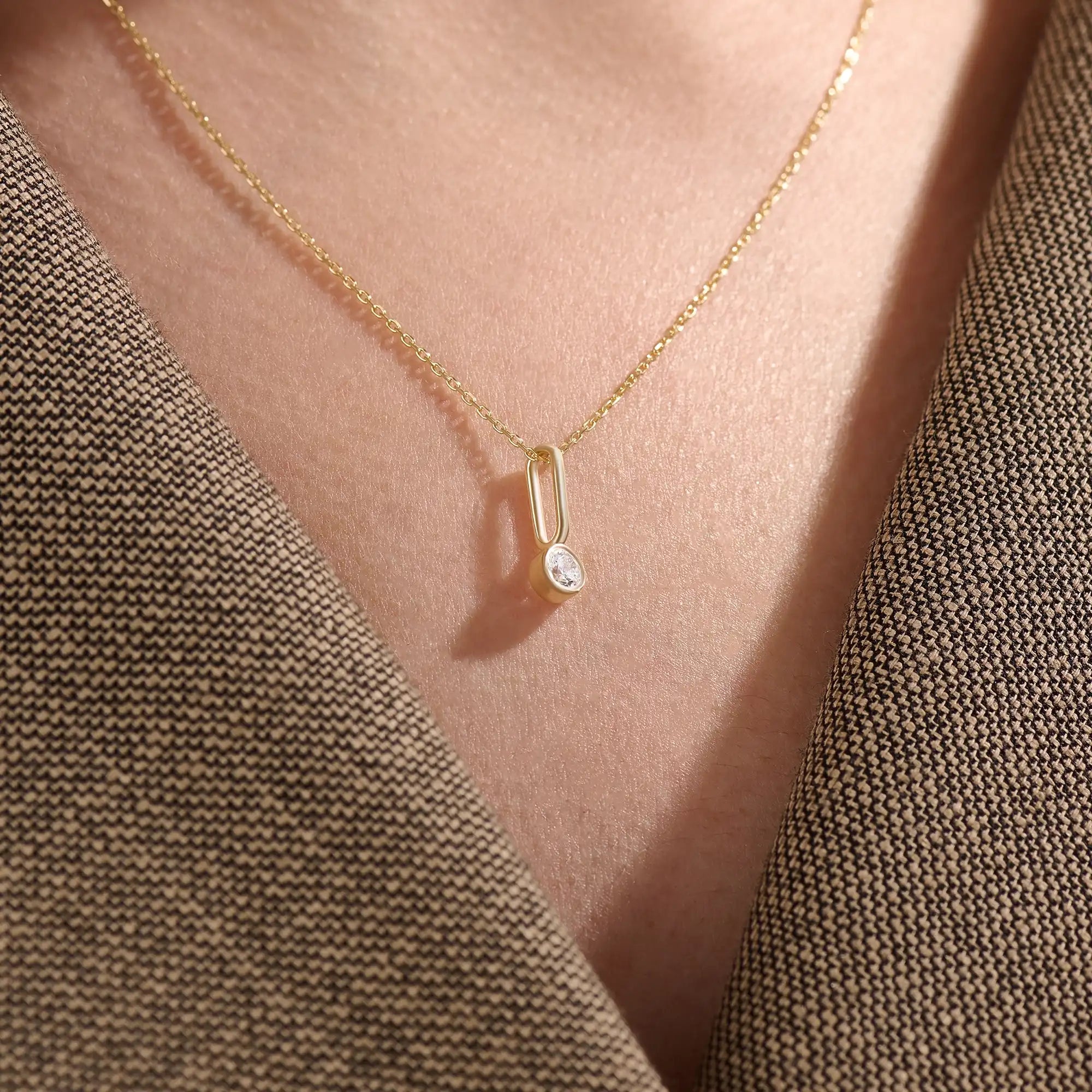 Model wearing a 14k gold vermeil unique solo necklace featuring a delicate chain and minimalist pendant with a single sparkling cubic zirconia, perfect for everyday refinement.
