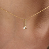 Model wearing a 14k gold vermeil unique solo necklace featuring a delicate chain and minimalist pendant with a single sparkling cubic zirconia, perfect for everyday refinement.
