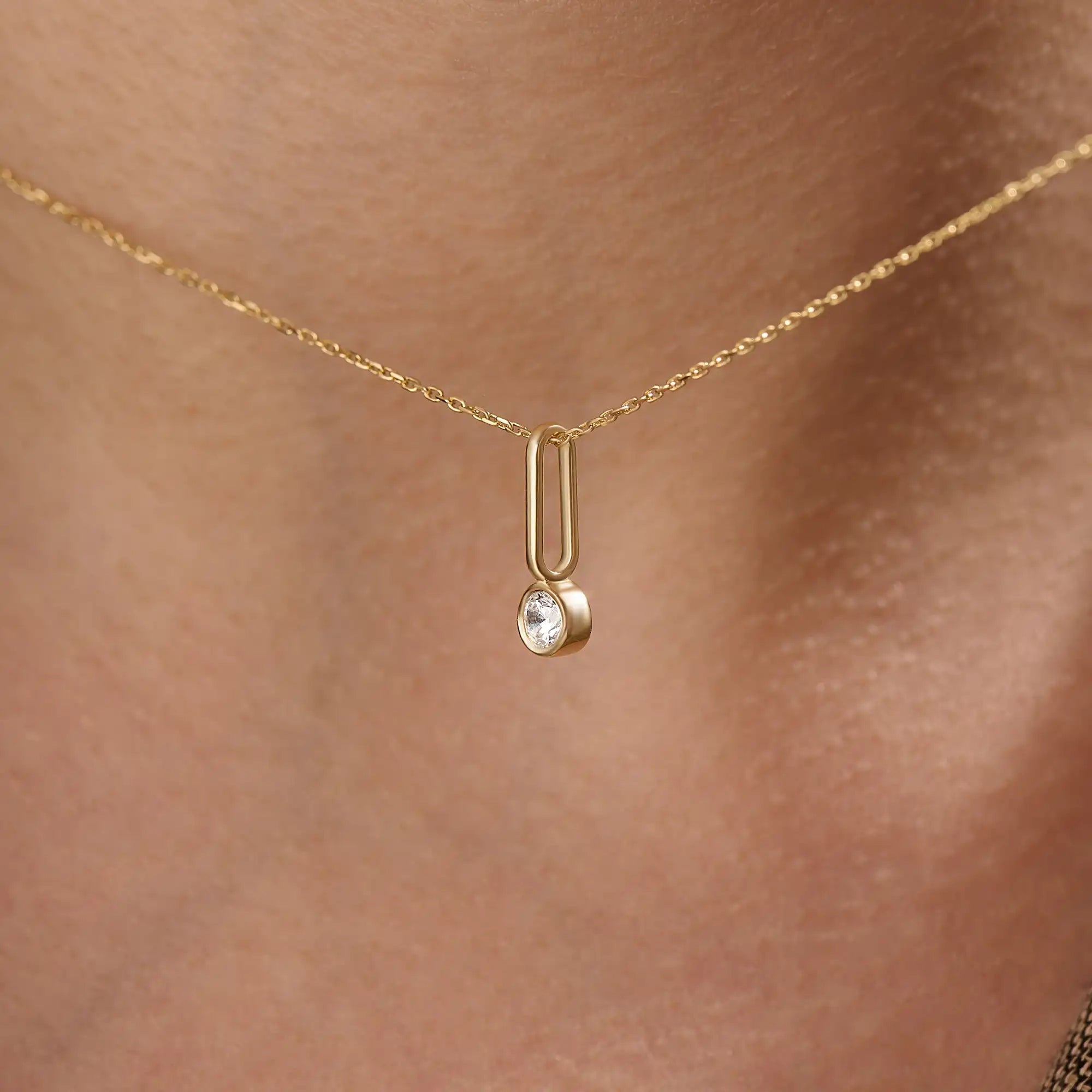 Model wearing a 14k gold vermeil unique solo necklace featuring a delicate chain and minimalist pendant with a single sparkling cubic zirconia, perfect for everyday refinement.
