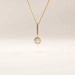 Side view of 14k gold vermeil unique solo necklace highlighting the elongated bail and brilliant round cubic zirconia centerpiece in a clean modern design.
