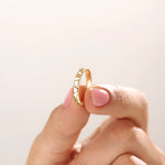 Model wearing a 14k gold vermeil unique wedding band with sculpted facets that reflect light beautifully, blending contemporary style with classic warmth.
