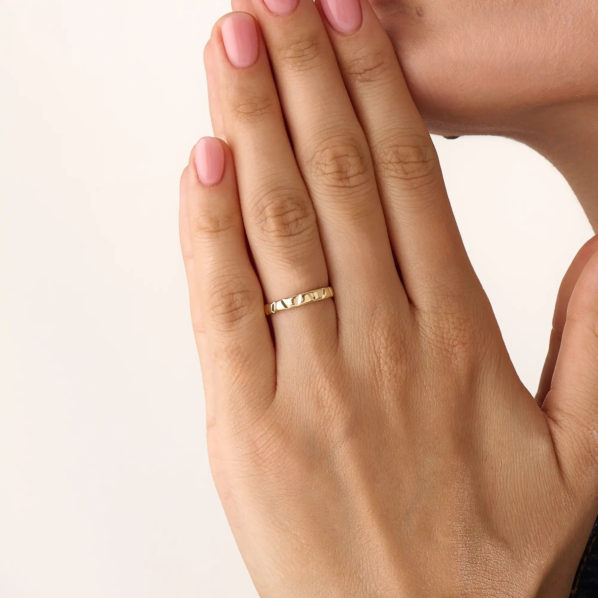 Model wearing a 14k gold vermeil unique wedding band with sculpted facets that reflect light beautifully, blending contemporary style with classic warmth.
