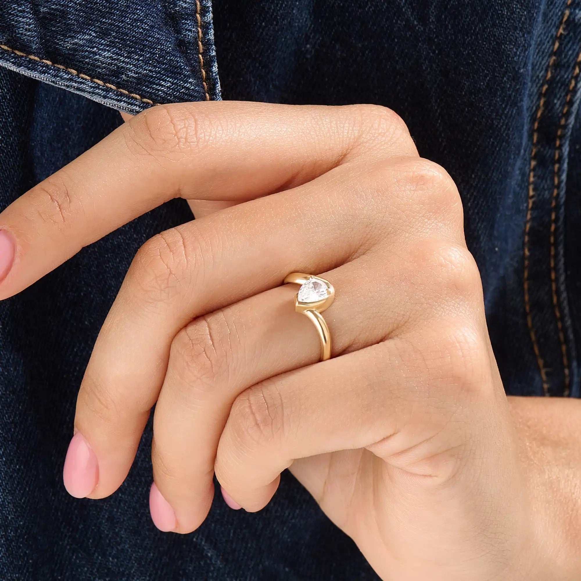 Model wearing a 14k gold vermeil wavy pear ring, showcasing its elegant wave design and radiant cubic zirconia gemstone with refined shine.
