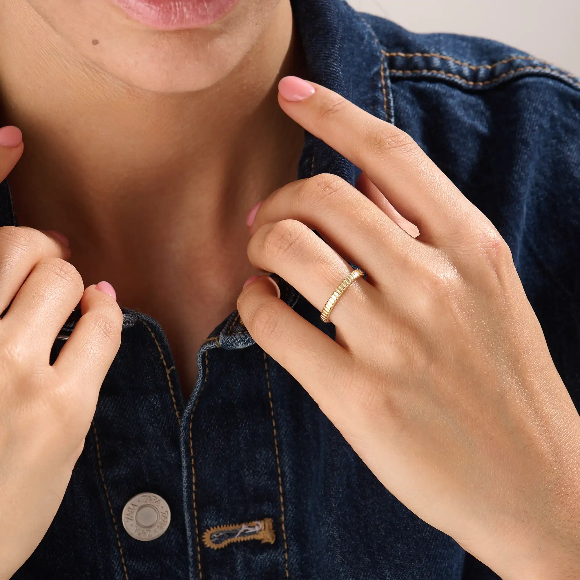 Model wearing a 14k gold vermeil minimalist band ring with ridged design, dainty gold stacking ring for women’s everyday look.

