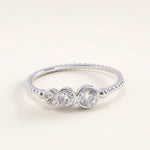 Silver vermeil beaded trio ring with three sparkling cubic zirconia stones set in smooth bezels on a polished beaded band, minimalist yet refined jewelry piece.
