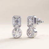 Silver vermeil toi et moi stud earrings showcasing a sleek modern design with emerald and round-cut cubic zirconia stones set in smooth bezels for a balanced, radiant look.
