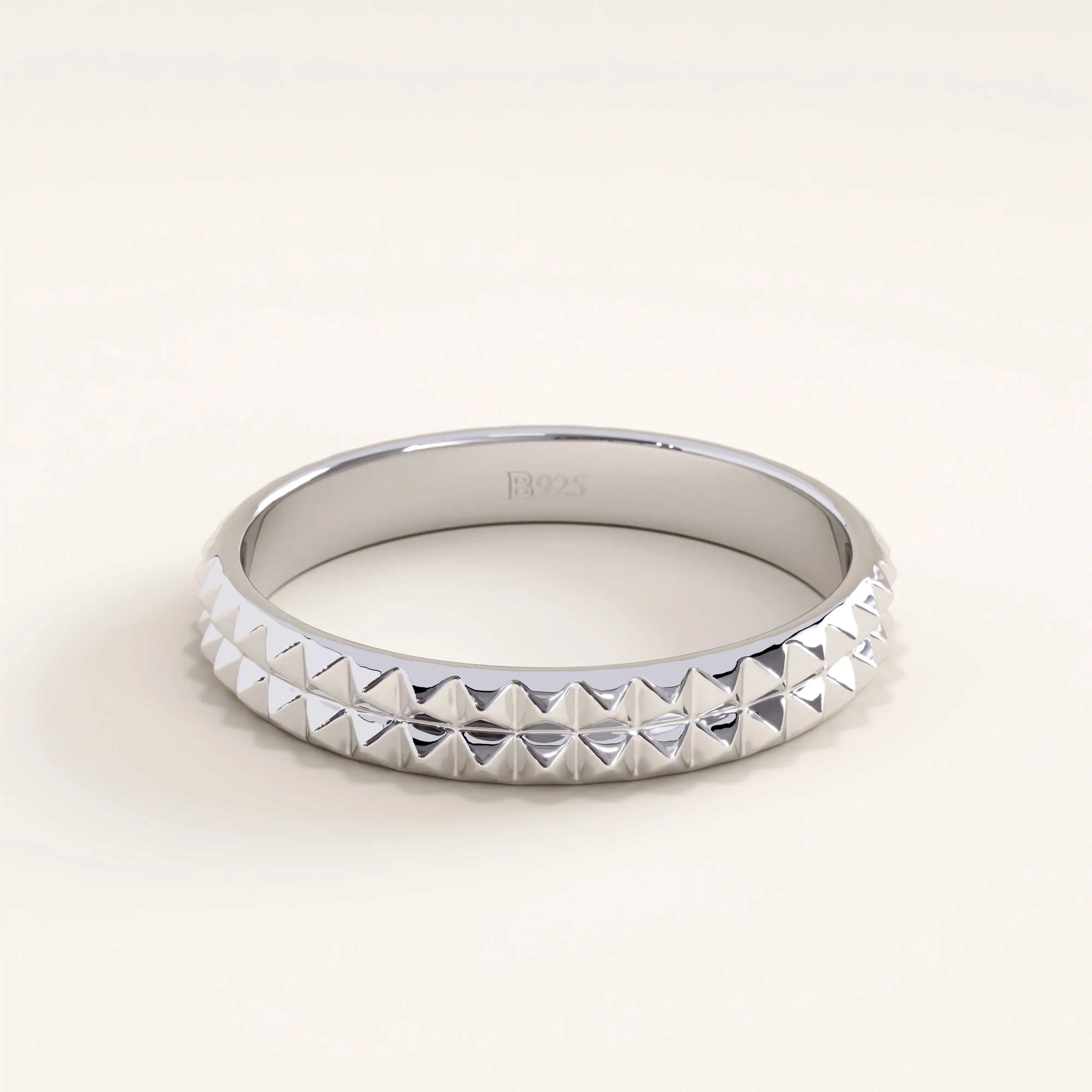 Silver vermeil square band ring with pyramid-like detailing and reflective surface, offering a bold yet refined everyday accessory.
