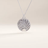 Silver vermeil sunrise coin necklace showcasing a circular pendant engraved with a rising sun design and subtle texture, blending artistry with timeless sophistication.
