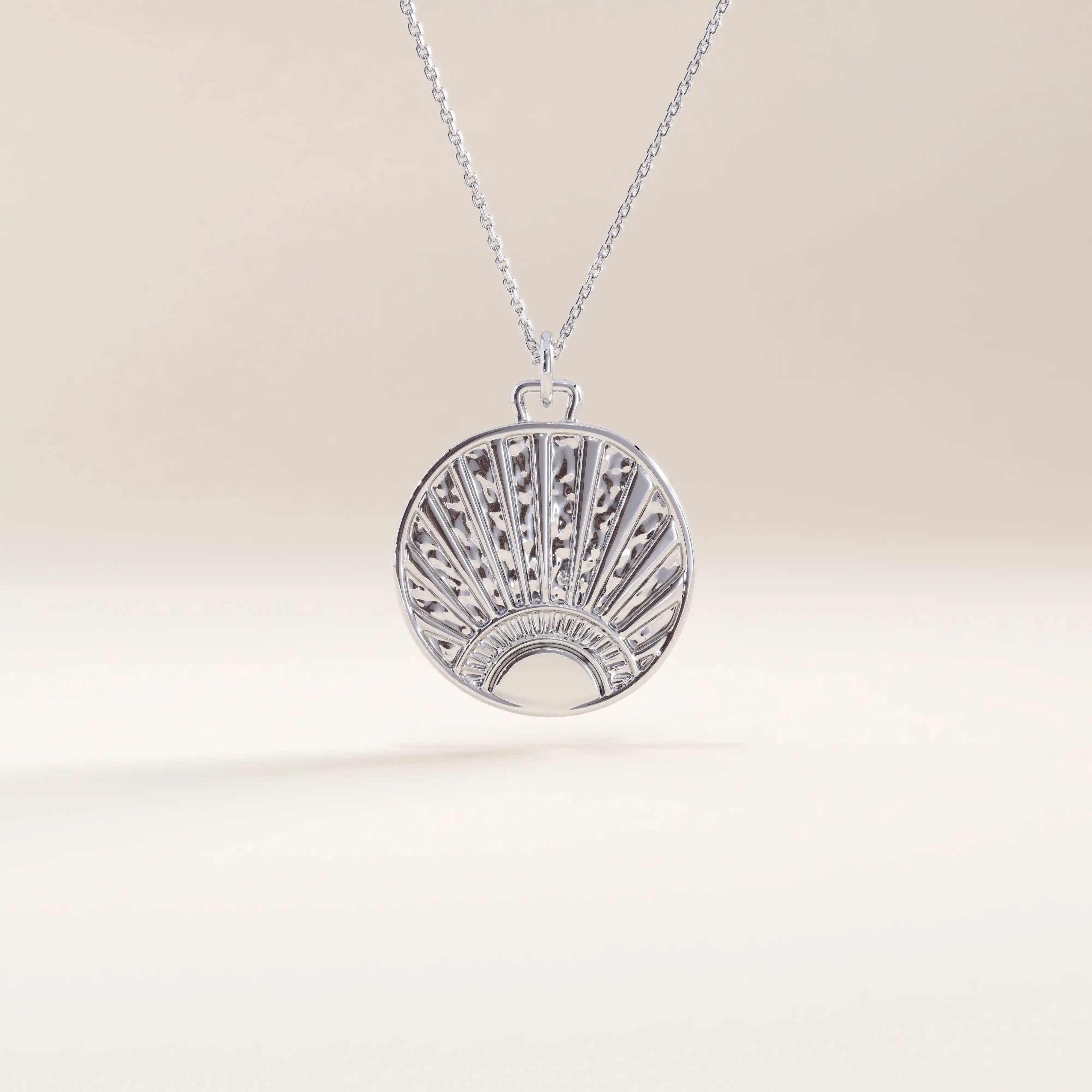 Silver vermeil sunrise coin necklace showcasing a circular pendant engraved with a rising sun design and subtle texture, blending artistry with timeless sophistication.
