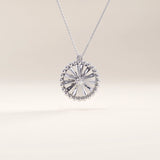 Silver vermeil textured coin necklace showcasing a circular pendant with a sculpted sunburst design and beaded edge, centered with a sparkling cubic zirconia for timeless shine.
