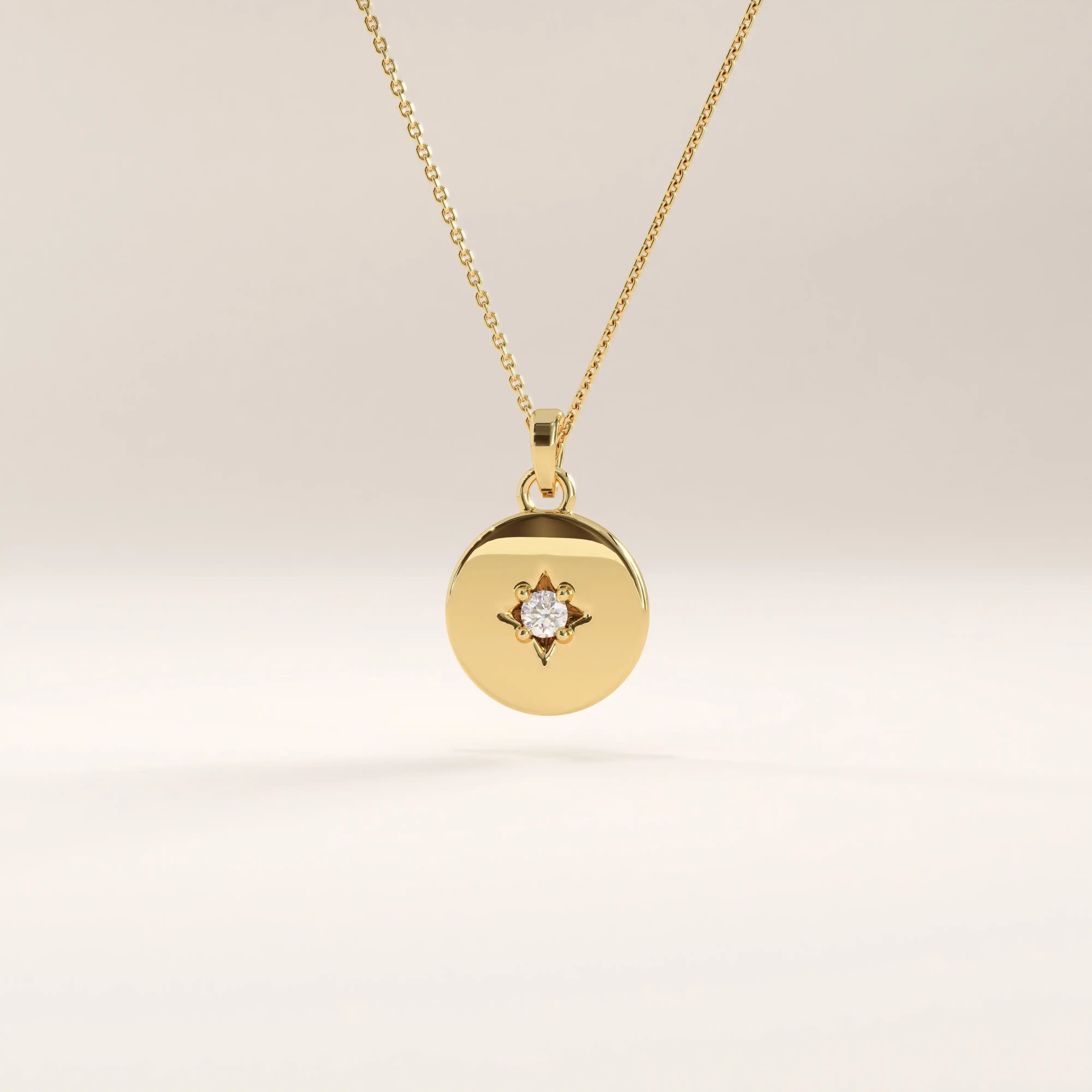 14k gold vermeil starburst coin necklace featuring a polished round pendant adorned with a radiant star engraving and a sparkling cubic zirconia at the center.
