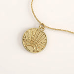 14k gold vermeil sunrise coin necklace featuring a round pendant with a radiant sun motif and hammered detailing that captures light beautifully for a warm, elegant glow.
